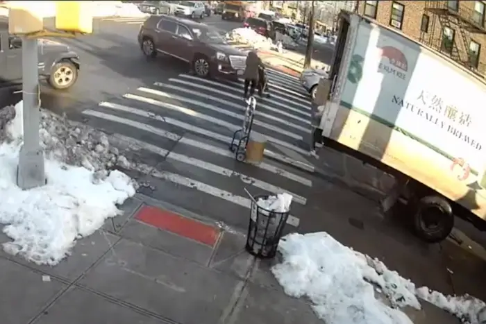 Video still from NYPD surveillance footage shows an SUV driver about to hit a woman pushing a toddler in a stroller